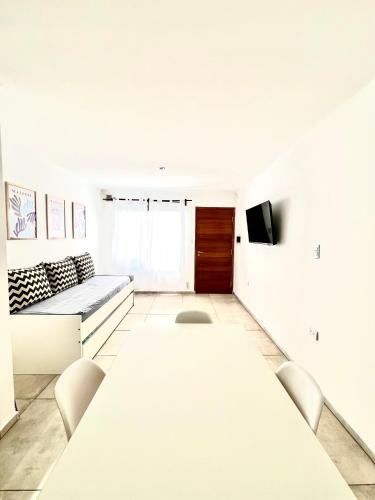 a white room with a long table and chairs at FINCA NOVA Apartment 7 in Balcarce