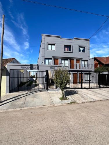 a large house with a fence in front of it at FINCA NOVA Apartment 7 in Balcarce