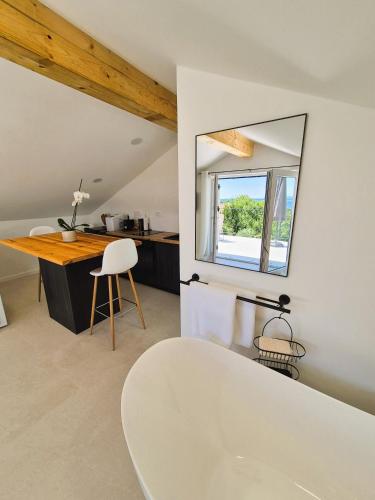 a bathroom with a white tub and a mirror at Casa Joy in Premantura