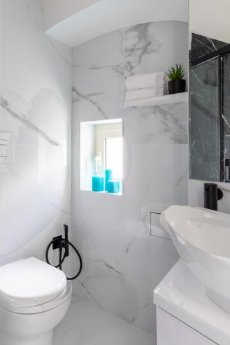 a white bathroom with a toilet and a sink at APARTAMENT OLIWIA - Julia Vieste in Vieste