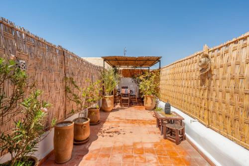 an outdoor patio with chairs and potted plants at Dar Karole-Privé-petits déjeuners inclus in Marrakech