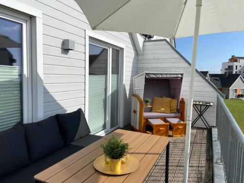 a patio with a table and an umbrella at Hoppetosse in Olpenitz