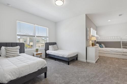a white bedroom with two beds and a window at 390 Strand Drive in Melbourne Beach