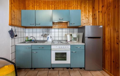 a kitchen with blue cabinets and a refrigerator at Gorgeous Apartment In Sveti Juraj With Wifi in Sveti Juraj
