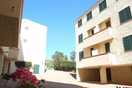 a building next to a building with pink flowers at Blu Baita in La Maddalena