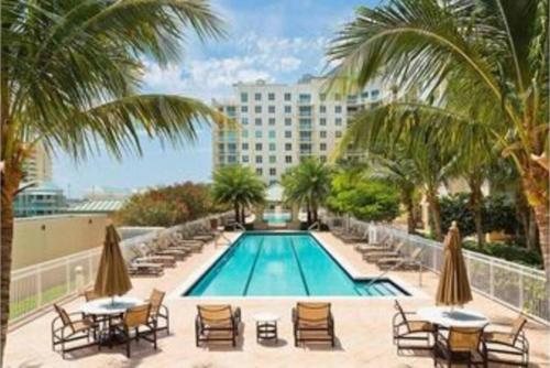 a swimming pool with chairs and tables and a hotel at Apartment in Casa Costa condo!Beach pass included in Boynton Beach