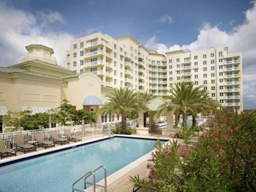 a hotel with a swimming pool in front of a building at Apartment in Casa Costa condo!Beach pass included in Boynton Beach