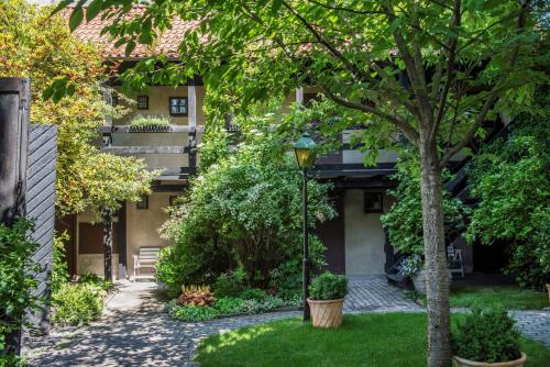 un patio con un árbol y un edificio en Värdshuset Lindgården, en Visby