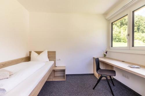 a bedroom with a bed and a desk and a chair at Haus Gaues in Dalaas