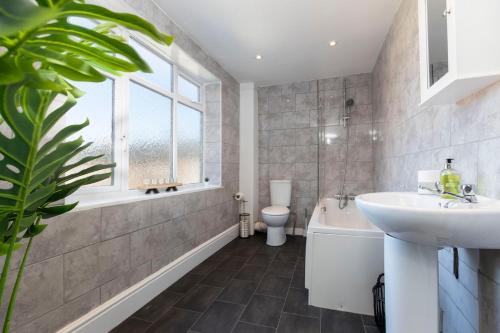a bathroom with a sink and a tub and a toilet at 4 BEDS, 4 BATHS home, central Darlington in Darlington