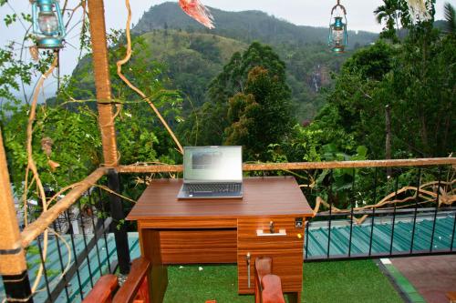 a laptop computer sitting on a desk on a balcony at Secret View Homestay Ella in Ella
