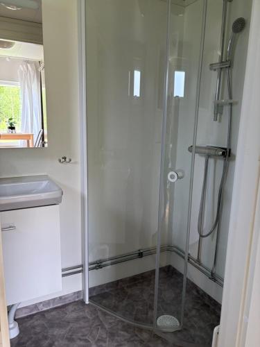 a shower in a bathroom with a glass shower stall at Mysig attefallare mitt i Vemdalen by in Vemdalen