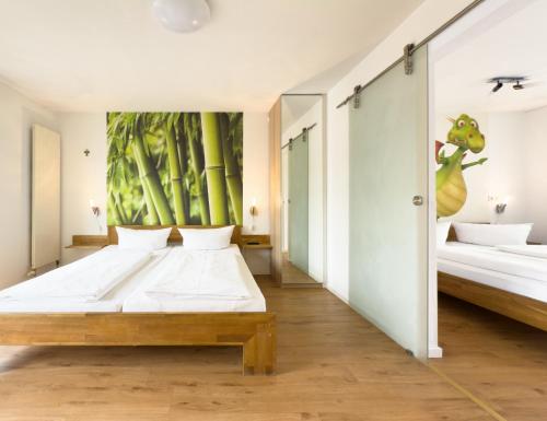 a bedroom with two beds and a mural of bamboo at Ruster Drachennest - Europa Park by living TIMELESS in Rust