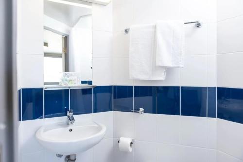a bathroom with a sink and blue and white tiles at Burley Road in City Centre - Leeds in Leeds