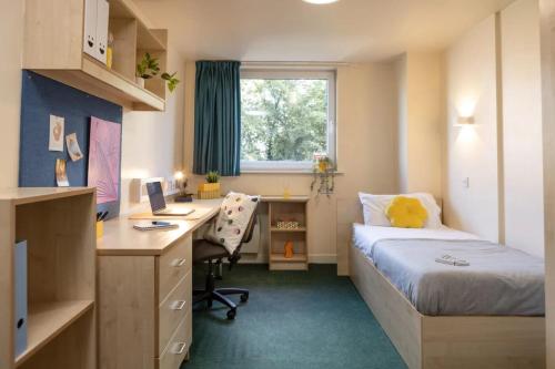 a small room with a bed and a desk and a computer at Burley Road in City Centre - Leeds in Leeds