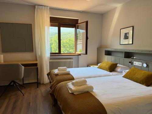 a hotel room with two beds and a window at Hotel Rural Venero Claro by Kerbest in Navaluenga