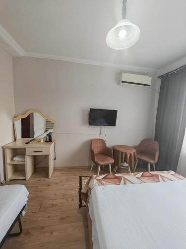 a bedroom with two beds and a desk and a mirror at Beta Uygun Palace in Edirne