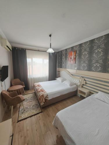a hotel room with two beds and a chair at Beta Uygun Palace in Edirne