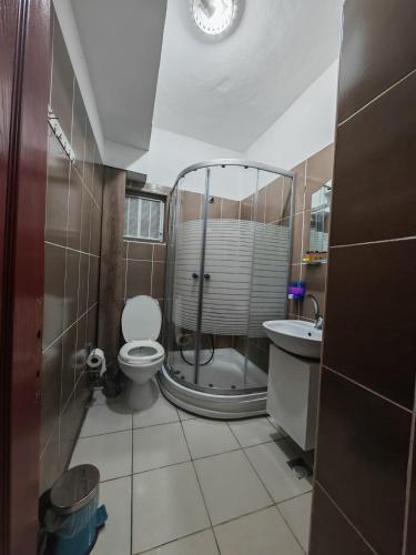 a bathroom with a shower and a toilet and a sink at Beta Uygun Palace in Edirne