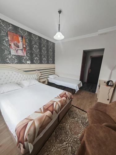 a bedroom with a large bed and a couch at Beta Uygun Palace in Edirne
