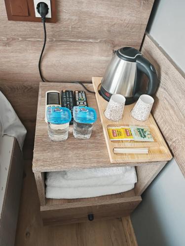 a nightstand with a tea kettle and glasses of water on it at Beta Uygun Palace in Edirne