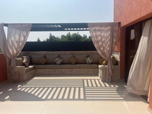 a living room with a couch on a patio at Villa SAKINA in Aghmat