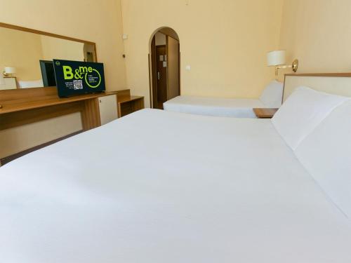 a large white bed in a hotel room at B&B HOTEL Riviera Celle Ligure in Celle Ligure