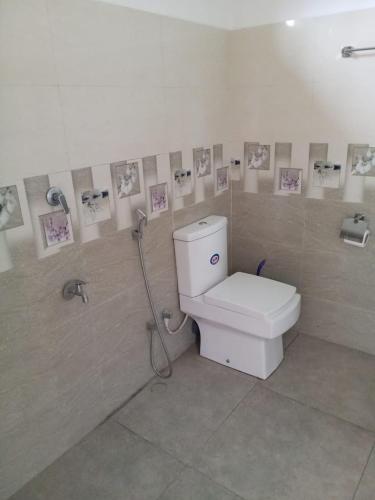 a bathroom with a toilet with pictures on the wall at Sadula Home Villa Ella in Ella