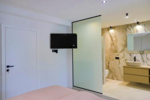 a bedroom with a sliding glass door with a tv on the wall at Casa Dellˇ Amore in Bihać