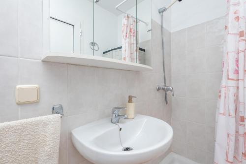 a white bathroom with a sink and a mirror at Sa Corterada in El Port de la Selva