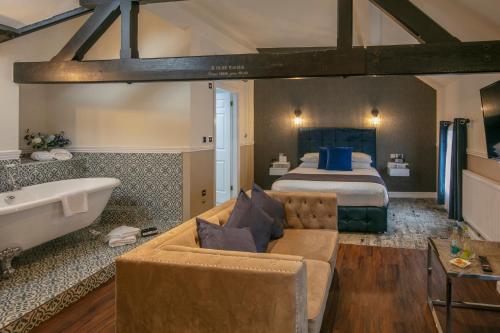 a hotel room with a bed and a tub and a couch at Best Western Lichfield City Centre The George Hotel in Lichfield