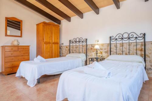 a bedroom with two beds with white sheets at Sa Corterada in El Port de la Selva