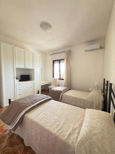 a bedroom with two beds and a desk and a window at Il giardino del Sole in Florinas