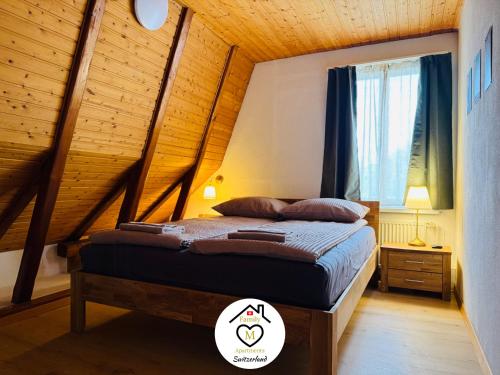 a bedroom with a bed with a wooden ceiling at Family M Apartments 35-36 - Aarau West - Center in Unterentfelden