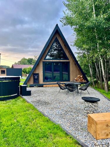 a small cabin with a table and chairs in a yard at Jelenie Brdy in Brzegi Dolne