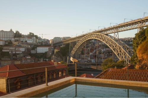 a bridge with a bird sitting on top of a building at Porto River Soul Hotel in Vila Nova de Gaia