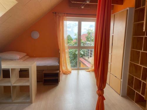 Zimmer mit einem Bett und einem großen Fenster in der Unterkunft Ferienhaus am Waldrand Village Holiday home in Bobenheim am Berg