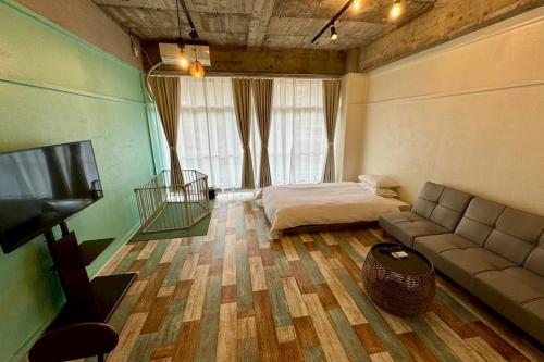 a room with a couch and a bed and a television at 白浜ペットフレンドリーハウス in Shirahama