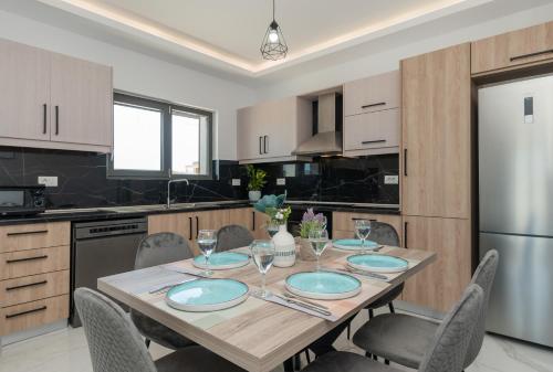 a kitchen with a table with chairs and a refrigerator at Zante Escape Suites by "elite" in Laganas