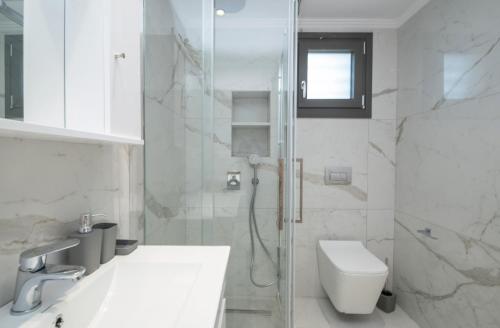 a bathroom with a shower and a toilet and a sink at Zante Escape Suites by "elite" in Laganas
