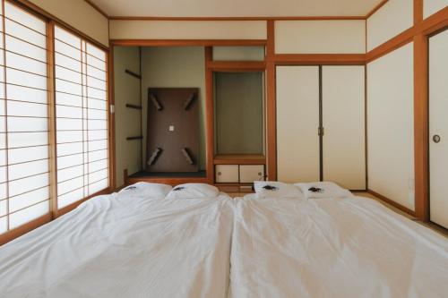 a room with two white sheets on a bed at Kumamoto Airport Villa 5 mins from Kumamoto Airport in Nishiharamura