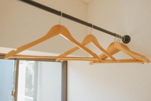 a rack with two wooden hangers hanging from a ceiling at Kumamoto Airport Villa 5 mins from Kumamoto Airport in Nishiharamura