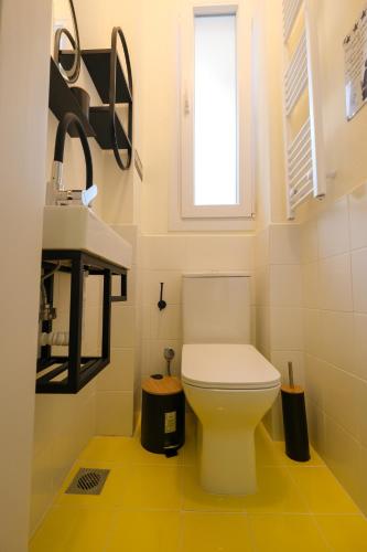 a bathroom with a white toilet and a sink at AG Living One in Thessaloniki