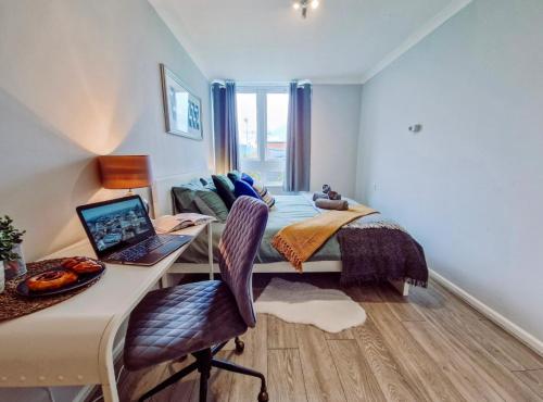 a bedroom with a bed and a desk with a laptop at NEW, Refurbished Modern & Spacious 1 Bed Flat Westfield Shepherd's Bush Free Wi-Fi Super King Bed in London
