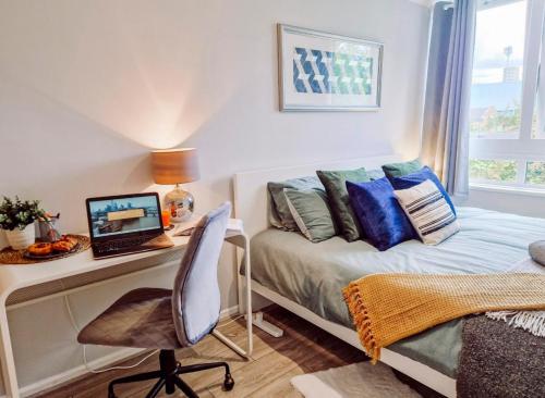 a bedroom with a bed and a desk with a computer at NEW, Refurbished Modern & Spacious 1 Bed Flat Westfield Shepherd's Bush Free Wi-Fi Super King Bed in London