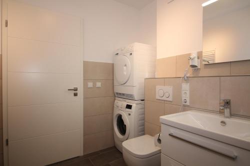 a bathroom with a washing machine and a washer at Wohnen am Yachthafen W46 in Cuxhaven