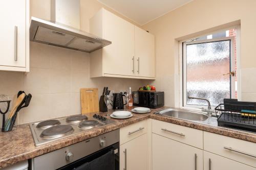 a kitchen with white cabinets and a sink at Open Mind Property - Cozy Studio Flat in Bournemouth