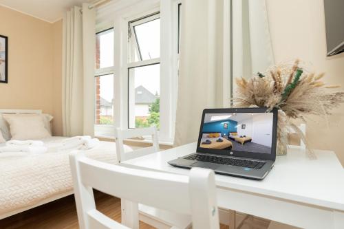 a laptop computer sitting on a white desk in a room at Open Mind Property - Cozy Studio Flat in Bournemouth