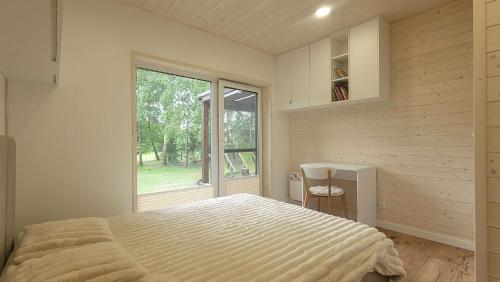 a bedroom with a large bed and a window at Wiosłem w Hamaku Domek nad Wkrą 