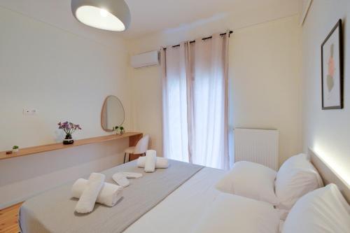 a white bedroom with a white bed and a window at AG Living One in Thessaloniki